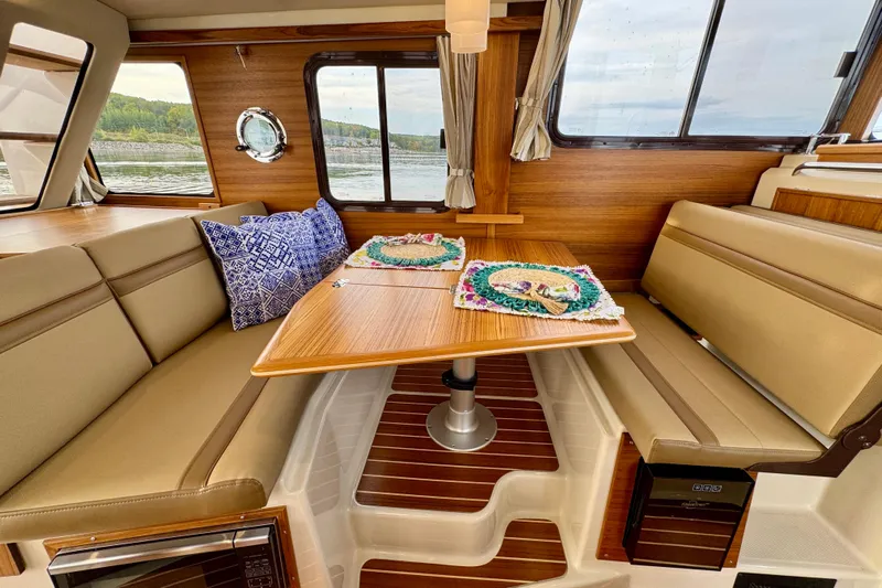  Yacht Photos Pics Interior of 2025 Ranger Tugs R-31 CB with cozy dining area and scenic window views.