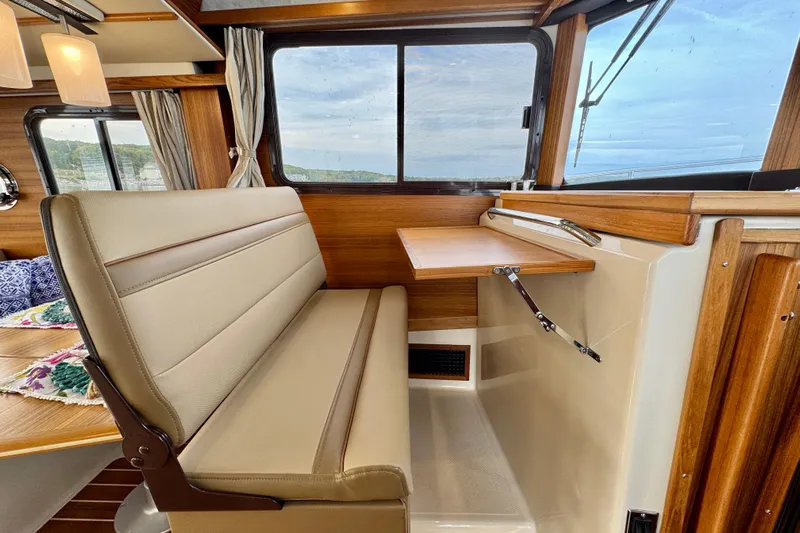  Yacht Photos Pics Interior of 2025 Ranger Tugs R-31 CB with foldable table and cushioned seating.
