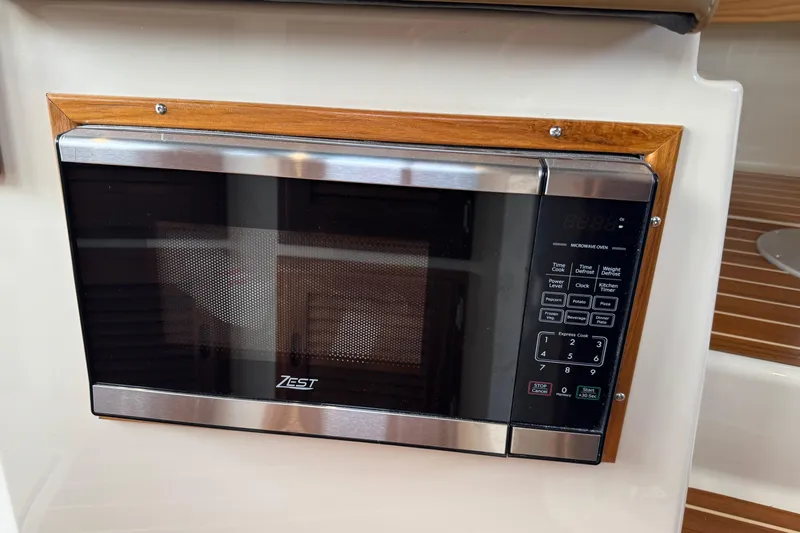  Yacht Photos Pics Microwave oven in 2025 Ranger Tugs R-31 CB boat interior, featuring wood trim.