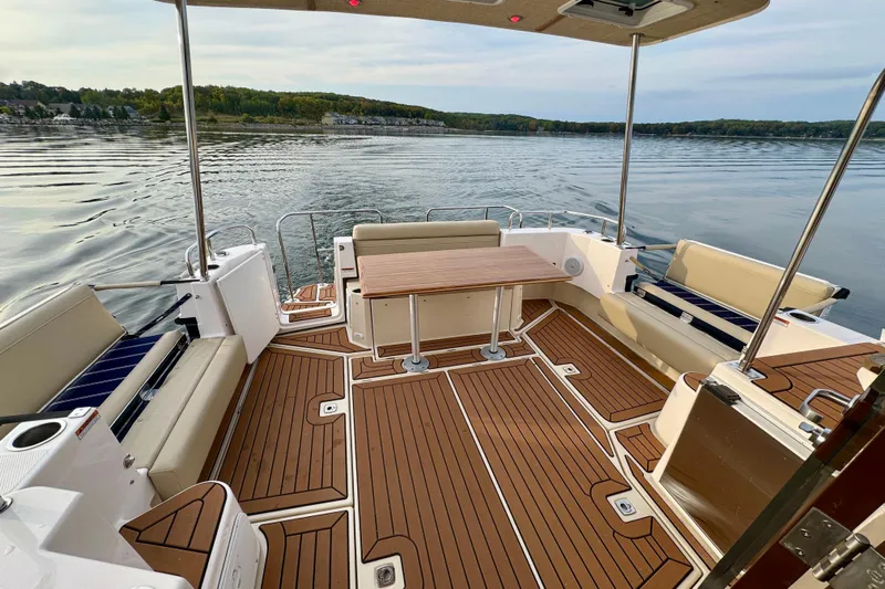  Yacht Photos Pics 2025 Ranger Tugs R-31 CB boat deck with seating and table on calm water.