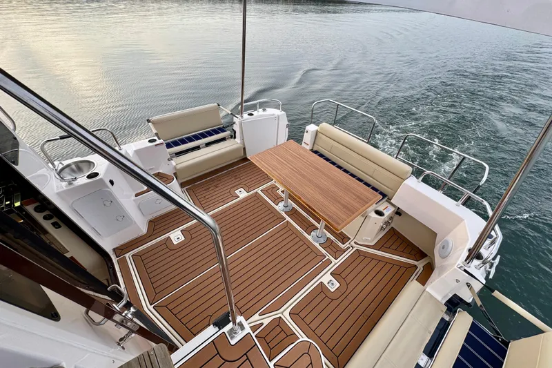  Yacht Photos Pics 2025 Ranger Tugs R-31 CB boat deck with seating and wooden table on calm water.