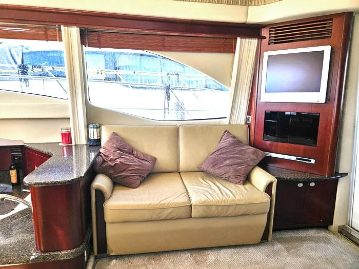  Yacht Photos Pics Luxurious interior of 2006 Sea Ray 44 Sedan Bridge yacht with sofa and entertainment system.