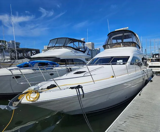  Yacht Photos Pics 2006 Sea Ray 44 Sedan Bridge yacht docked at marina under clear blue sky.