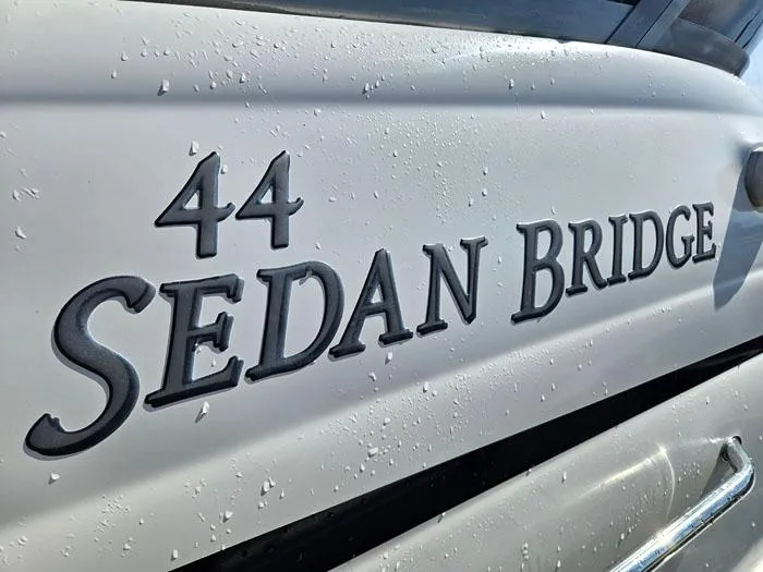  Yacht Photos Pics Close-up of 2006 Sea Ray 44 Sedan Bridge yacht nameplate with water droplets.