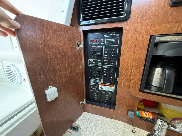  Yacht Photos Pics 2008 Hydra-Sports Vector 3500 VX electrical panel with open wooden cabinet door.