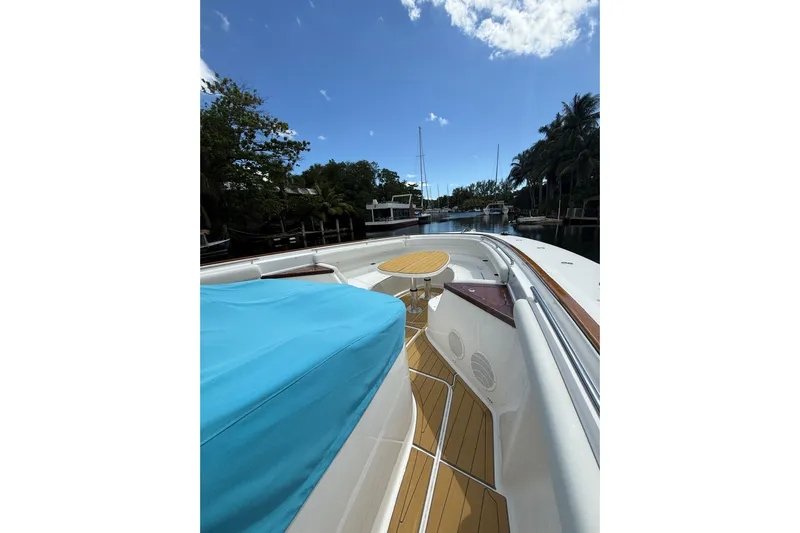  Yacht Photos Pics Luxury HCB 65 yacht deck with blue cover, wooden flooring, and scenic marina view.