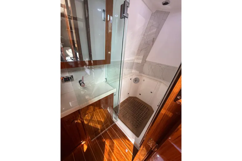  Yacht Photos Pics Luxurious bathroom interior of 2021 HCB 65 yacht with wooden accents and glass shower.