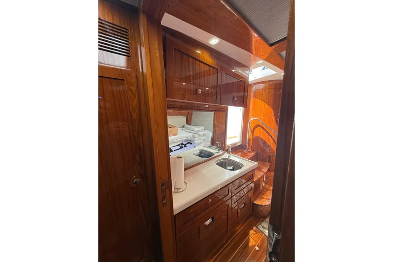  Yacht Photos Pics Luxurious wooden interior of 2021 HCB 65 yacht bathroom with sink and storage.