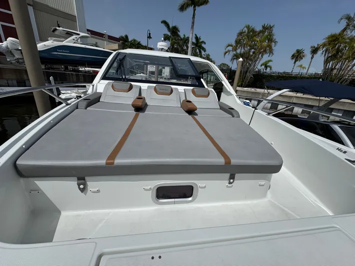 Eleven Eleven Yacht Photos Pics 2022 Beneteau Gran Turismo 32 yacht with spacious sunbathing area, docked near palm trees.