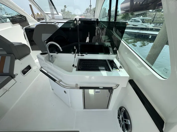 Eleven Eleven Yacht Photos Pics 2022 Beneteau Gran Turismo 32 yacht interior with kitchenette and seating area.