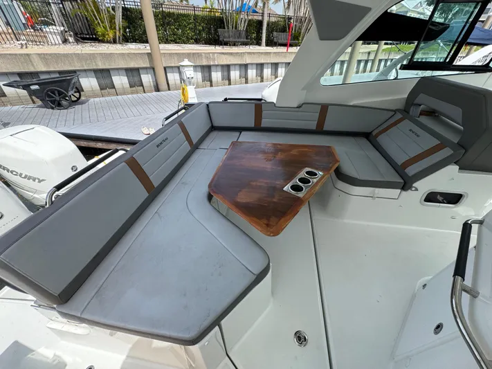 Eleven Eleven Yacht Photos Pics 2022 Beneteau Gran Turismo 32 interior with gray seating and wooden table.