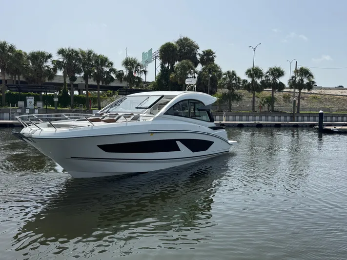 Eleven Eleven Yacht Photos Pics 2022 Beneteau Gran Turismo 32 yacht on calm water, surrounded by palm trees.