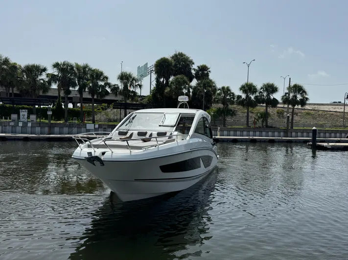 Eleven Eleven Yacht Photos Pics 2022 Beneteau Gran Turismo 32 yacht docked in a marina with palm trees.