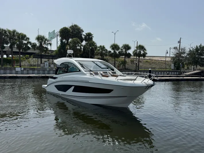 Eleven Eleven Yacht Photos Pics 2022 Beneteau Gran Turismo 32 yacht on calm water, surrounded by palm trees.