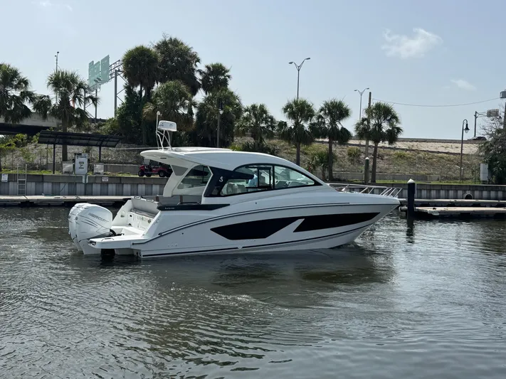 Eleven Eleven Yacht Photos Pics 2022 Beneteau Gran Turismo 32 yacht docked in a marina with palm trees.