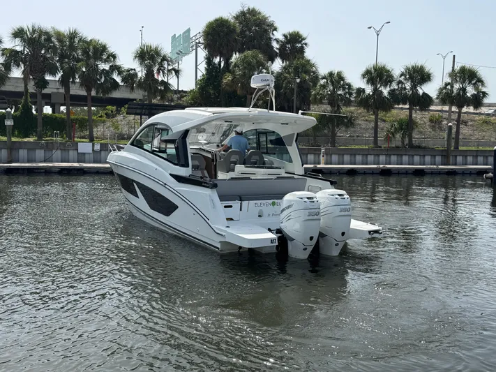 Eleven Eleven Yacht Photos Pics 2022 Beneteau Gran Turismo 32 yacht on water, surrounded by palm trees.