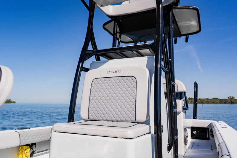  Yacht Photos Pics 2024 Dorado 25 boat with sleek seating and modern design on calm water.
