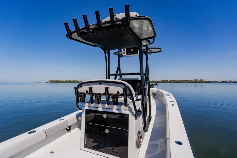  Yacht Photos Pics 2024 Dorado 25 boat on calm water, featuring sleek design and fishing rod holders.