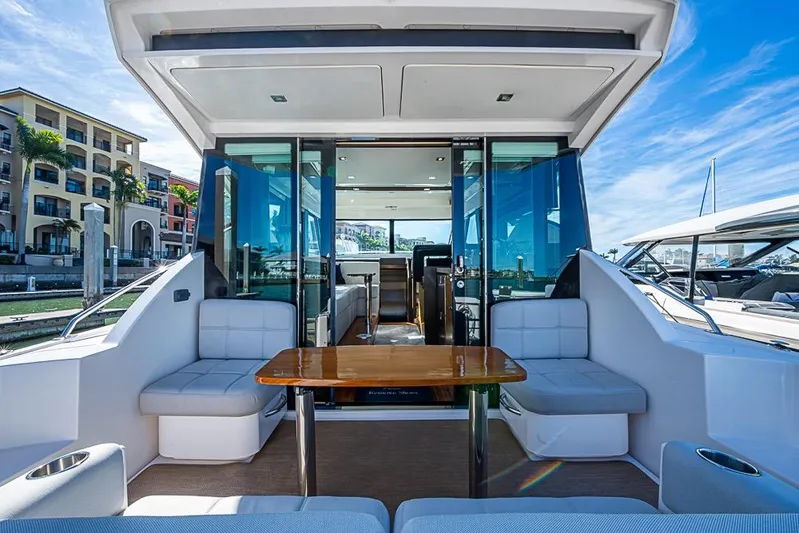 Exitevent Yacht Photos Pics 2017 Tiara Yacht Coupe with luxurious seating and table, docked at a marina.