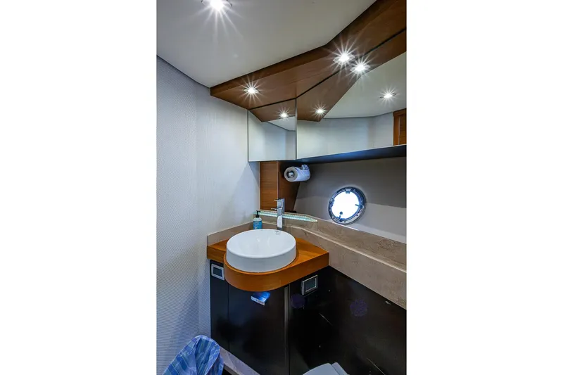 Exitevent Yacht Photos Pics Luxurious bathroom interior of 2017 Tiara Yacht coupe with modern fixtures and porthole window.