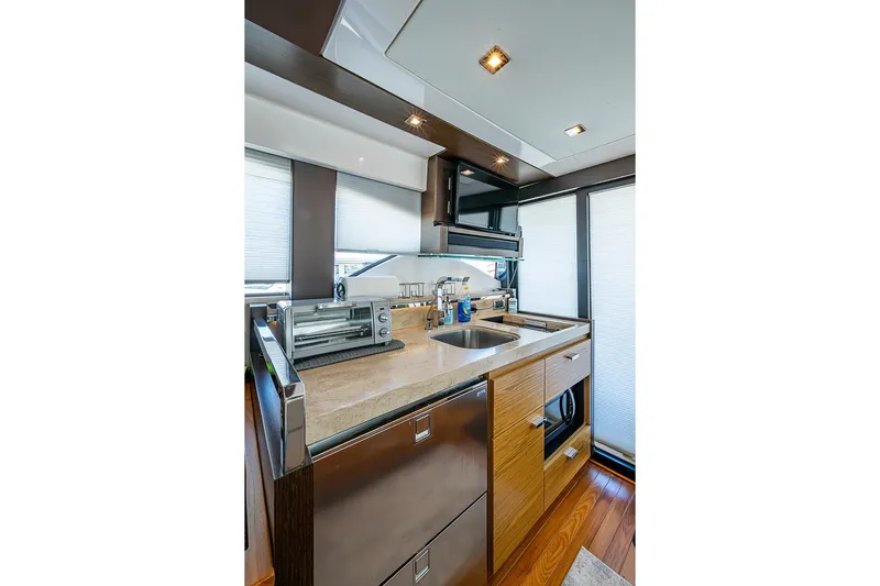 Exitevent Yacht Photos Pics Modern kitchen interior of 2017 Tiara Yacht coupe with sleek appliances and wood accents.