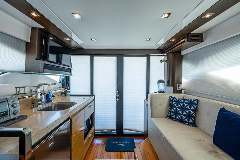 Exitevent Yacht Photos Pics Luxurious interior of 2017 Tiara Yacht coupe with modern kitchen and seating area.