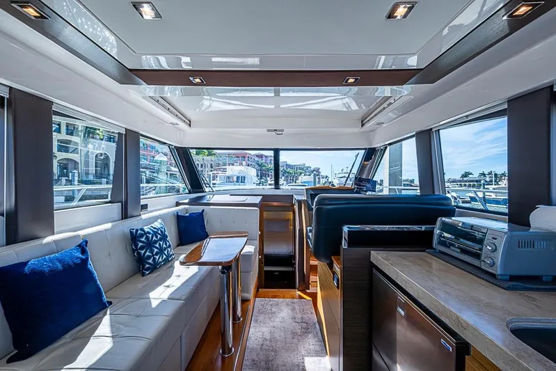 Exitevent Yacht Photos Pics Luxurious interior of 2017 Tiara Yacht Coupe with modern furnishings and panoramic windows.