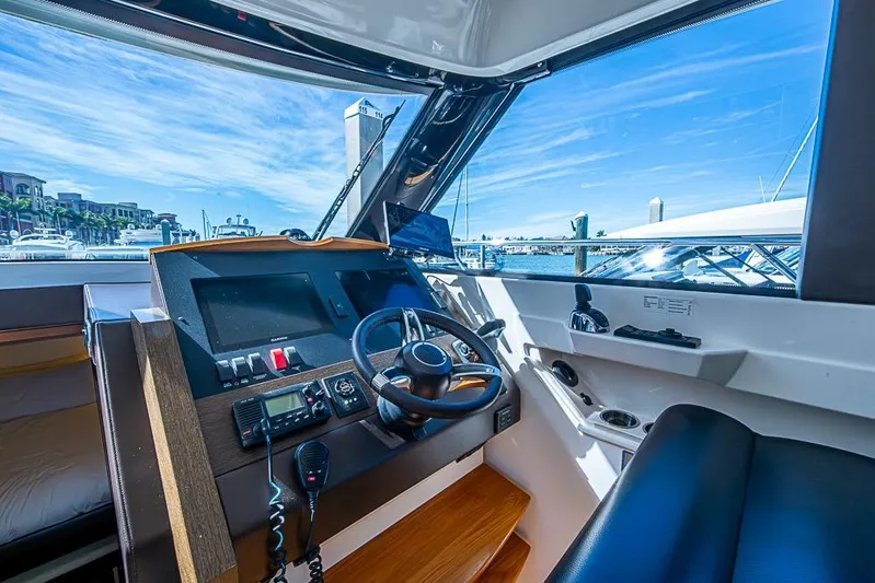 Exitevent Yacht Photos Pics 2017 Tiara Yacht Coupe helm with modern controls and marina view.