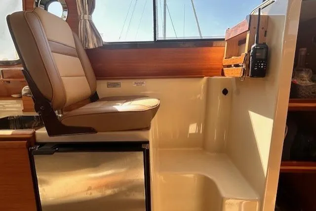  Yacht Photos Pics 2024 Ranger Tugs R-27 interior helm seat with fridge and radio.