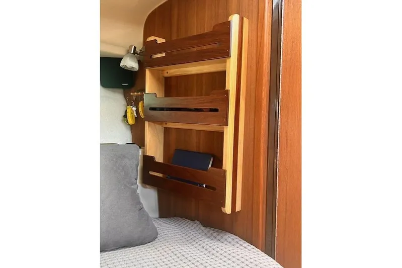  Yacht Photos Pics 2024 Ranger Tugs R-27 interior with wooden shelves and cozy bedding.