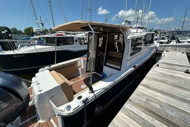  Yacht Photos Pics 2024 Ranger Tugs R-27 boat docked at marina, featuring spacious deck and modern design.