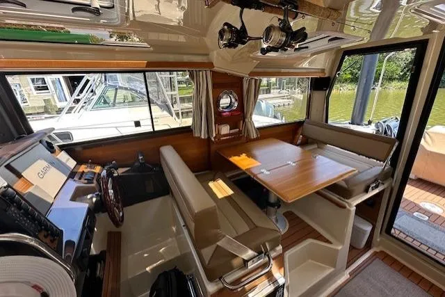  Yacht Photos Pics 2024 Ranger Tugs R-27 interior with helm, dining area, and large windows.