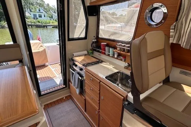  Yacht Photos Pics 2024 Ranger Tugs R-27 interior with kitchenette, seating, and outdoor view.