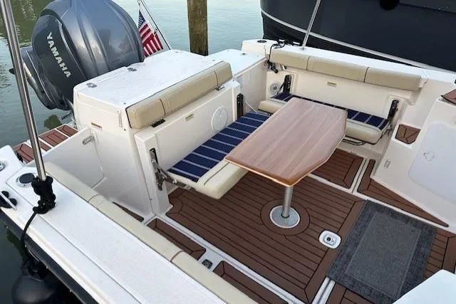  Yacht Photos Pics 2024 Ranger Tugs R-27 boat interior with seating, table, and Yamaha engine.