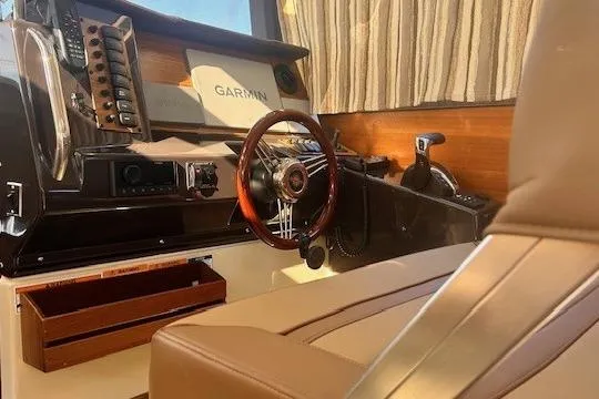  Yacht Photos Pics 2024 Ranger Tugs R-27 interior helm with Garmin navigation system and wooden steering wheel.
