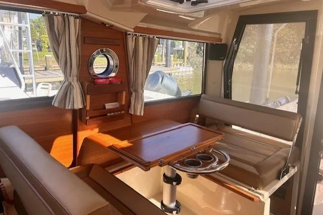  Yacht Photos Pics 2024 Ranger Tugs R-27 interior with seating, table, and windows.
