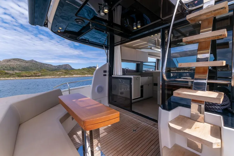  Yacht Photos Pics Luxurious 2020 Cranchi E 52S Evoluzione yacht interior with wooden stairs and seating area.