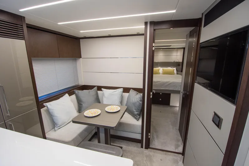  Yacht Photos Pics Luxurious interior of 2020 Sunseeker Predator 74 XPS yacht with dining area and bedroom.