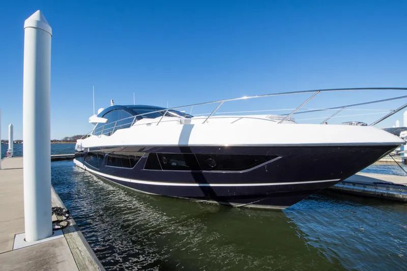  Yacht Photos Pics 2020 Sunseeker Predator 74 XPS yacht docked in marina under clear blue sky.