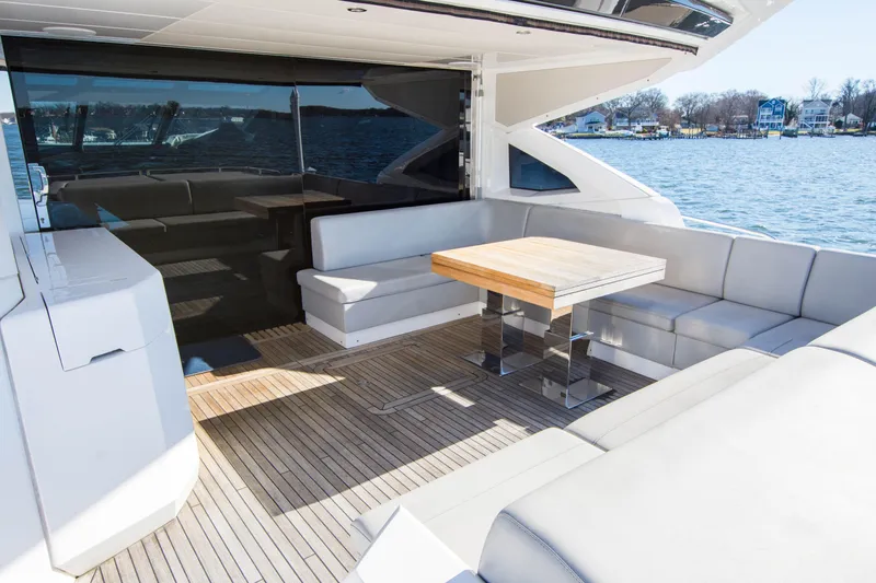 Yacht Photos Pics Luxury Sunseeker Predator 74 XPS yacht deck with seating and table, overlooking water.