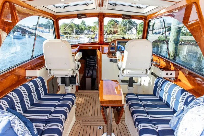 Gracious Yacht Photos Pics Interior of 2011 Hinckley Picnic Boat Mark III with striped seating and wooden finishes.