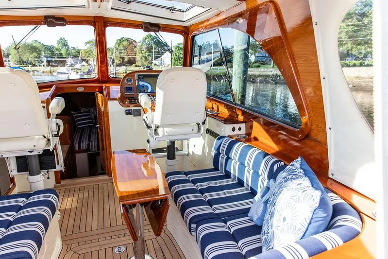 Gracious Yacht Photos Pics Luxurious 2011 Hinckley Picnic Boat Mark III interior with striped seating and polished wood finishes.