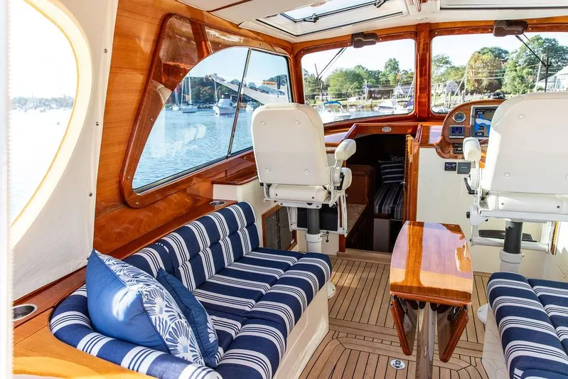 Gracious Yacht Photos Pics Luxurious 2011 Hinckley Picnic Boat Mark III interior with striped seating and wooden finishes.