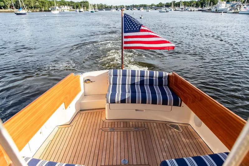 Gracious Yacht Photos Pics Hinckley Picnic Boat Mark III 2011 with American flag, cruising on a scenic waterway.