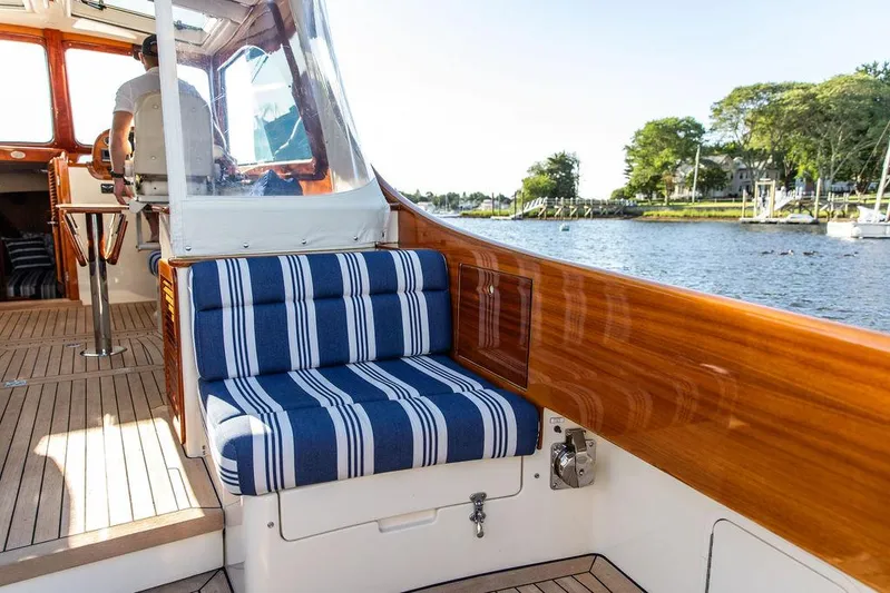 Gracious Yacht Photos Pics 2011 Hinckley Picnic Boat Mark III interior with striped seating, wooden finish, and scenic water view.