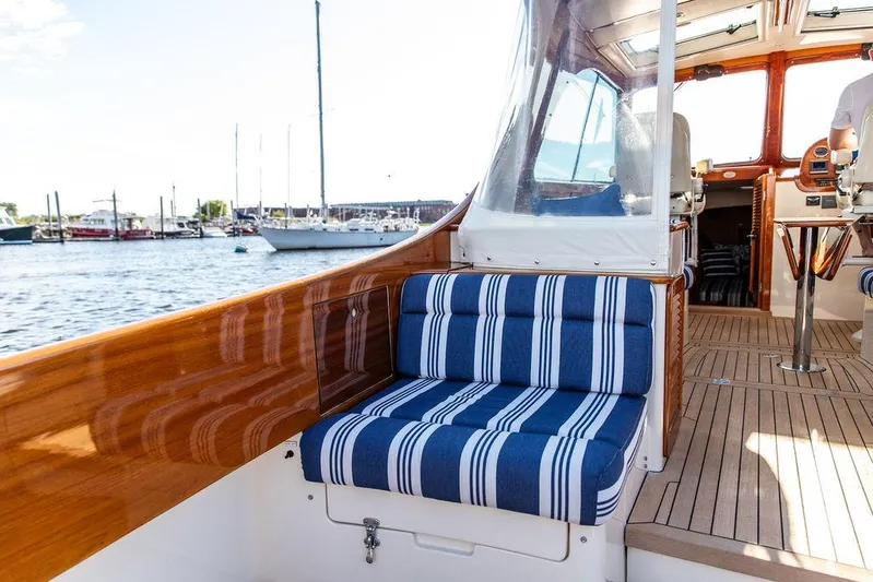 Gracious Yacht Photos Pics 2011 Hinckley Picnic Boat Mark III with striped seating, docked in a marina.