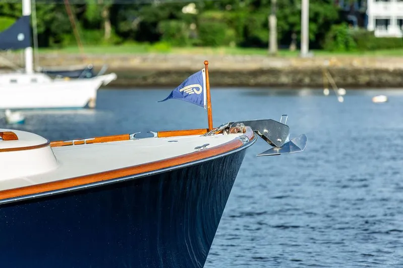 Gracious Yacht Photos Pics Hinckley Picnic Boat Mark III 2011, elegant bow with flag, anchored on calm water.