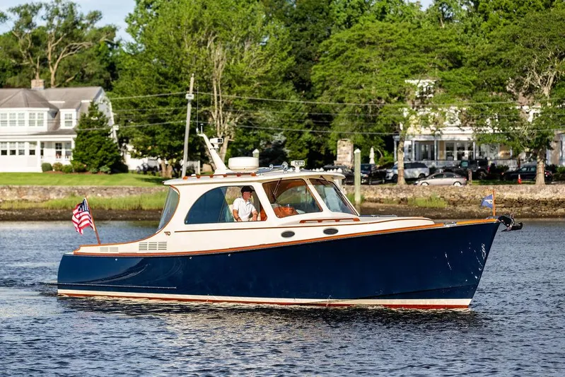 Gracious Yacht Photos Pics 2011 Hinckley Picnic Boat Mark III cruising on a scenic river with lush greenery.