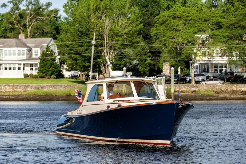 Gracious Yacht Photos Pics 2011 Hinckley Picnic Boat Mark III cruising on a scenic river near waterfront homes.