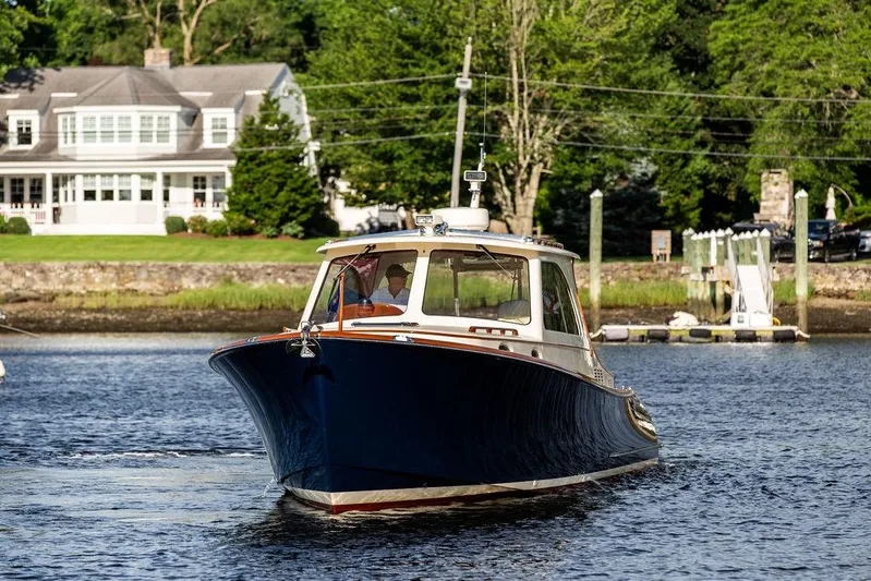Gracious Yacht Photos Pics 2011 Hinckley Picnic Boat Mark III cruising on a serene river near a charming house.
